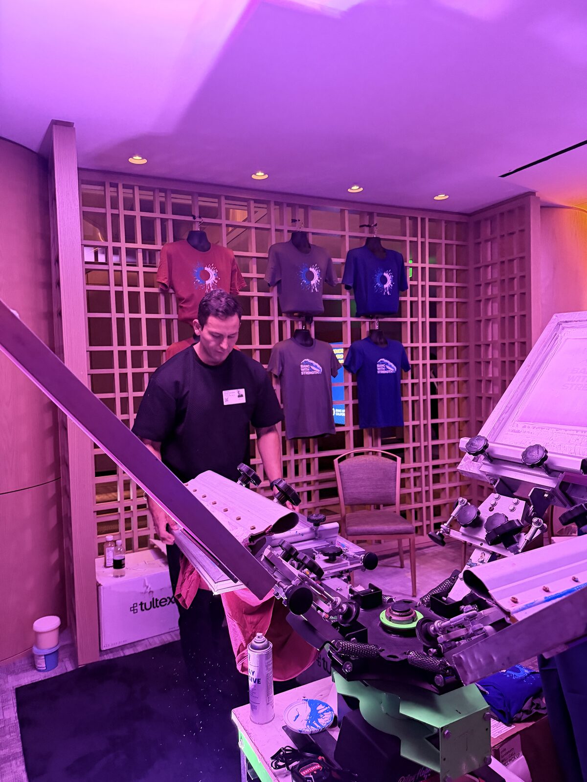 Operator loading a shirt onto the press at the shirt bar
