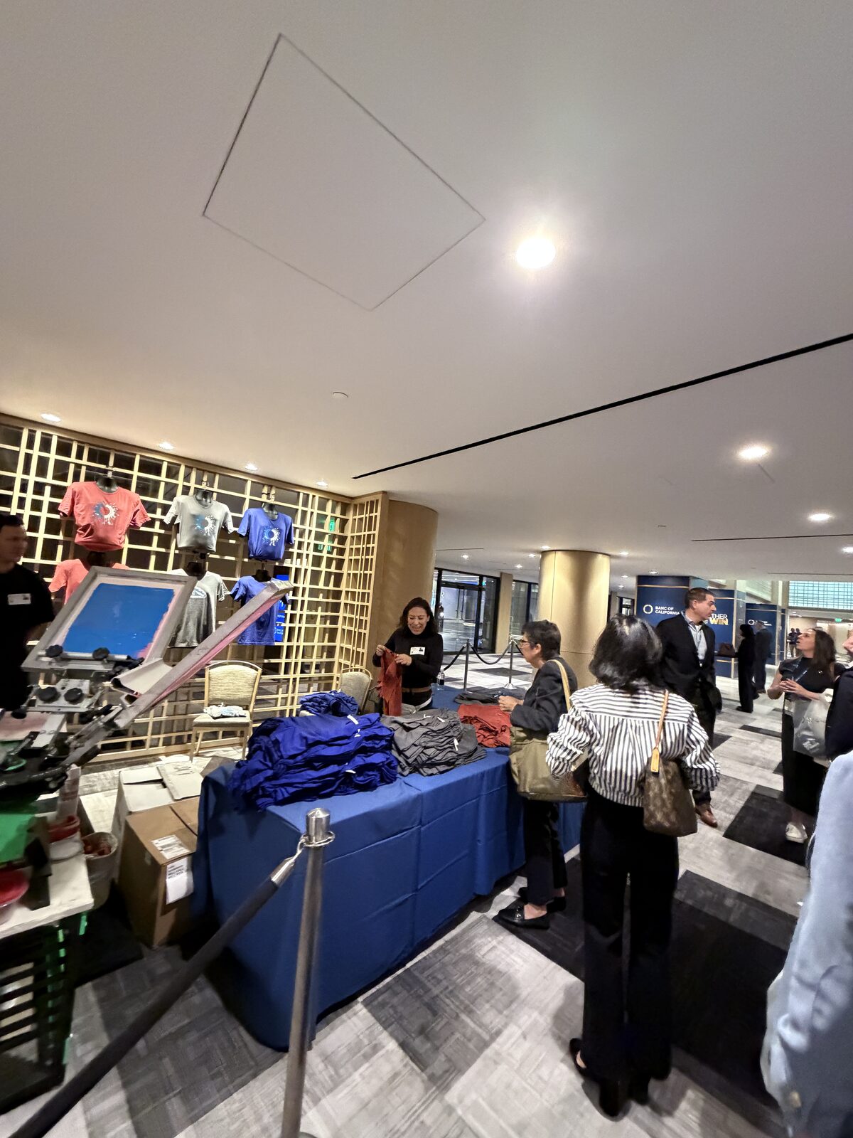 Handing a finished shirt to a guest at a summit