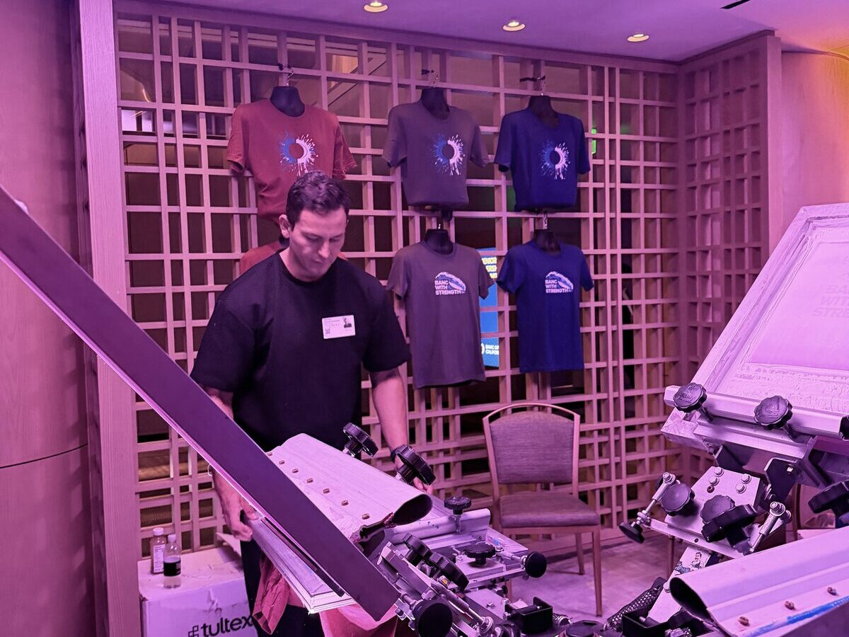 Staffed shirt bar station pressing custom tees live at an event